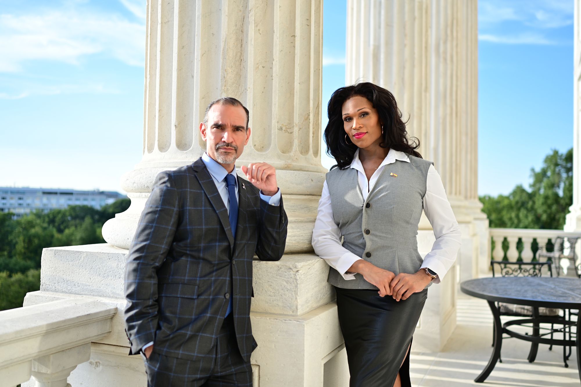 Two advocates stand between the columns of the U.S. Capitol