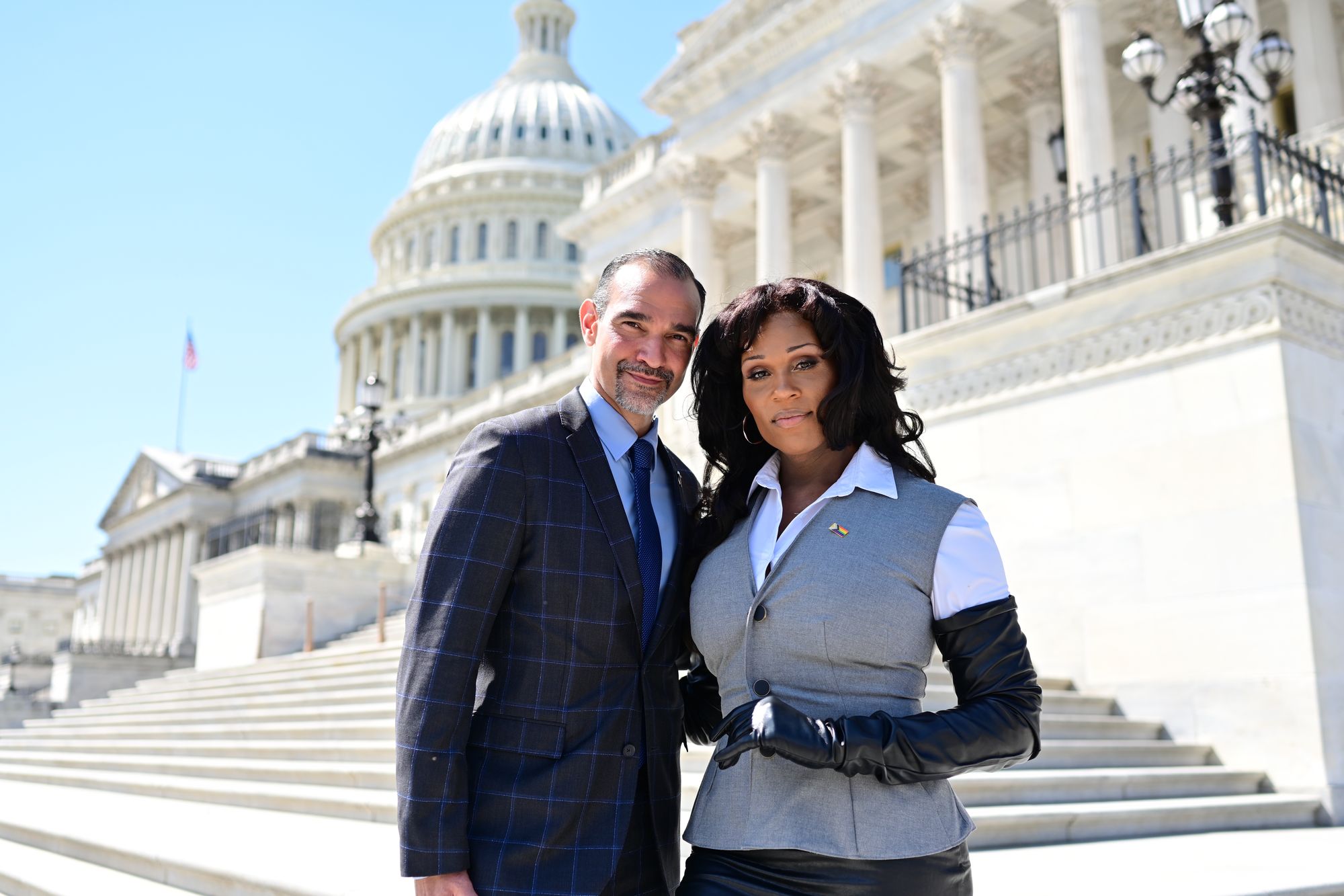 Two advocates stand together on the steps of the U.S. Capitol
