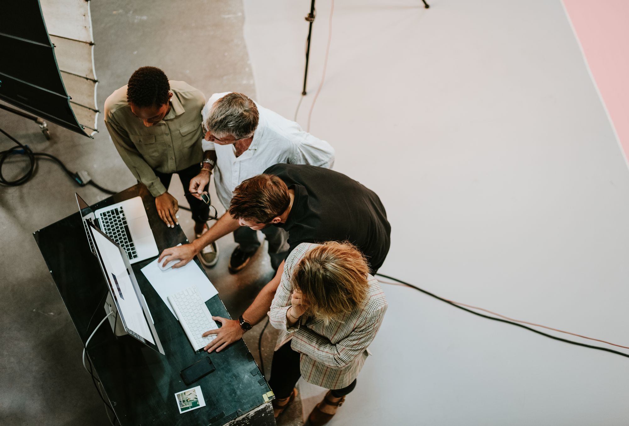 A production crew reviews footage on monitors from above, overhead view of a photo studio